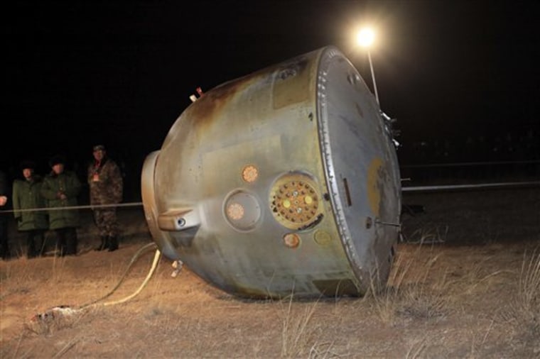 In this photo released by China's Xinhua News Agency, the re-entry capsule of Shenzhou 8 spacecraft lies on its side at a landing site located in Siziwang Banner in north China's Inner Mongolia Autonomous Region, Thursday, Nov. 17, 2011. The unmanned Chinese spacecraft returned to Earth on Thursday night after it docked twice with an orbiting module in preparation for the country launching its own space station. (AP Photo/Xinhua, Li Gang) NO SALES